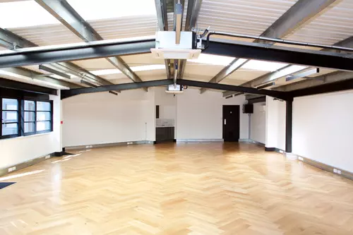 Large office space in Camden with laminate wooden floors and black metal beams 