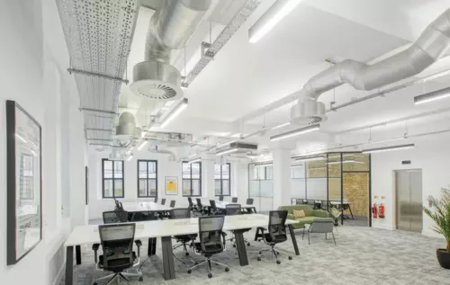 An office with black chairs and white tables.